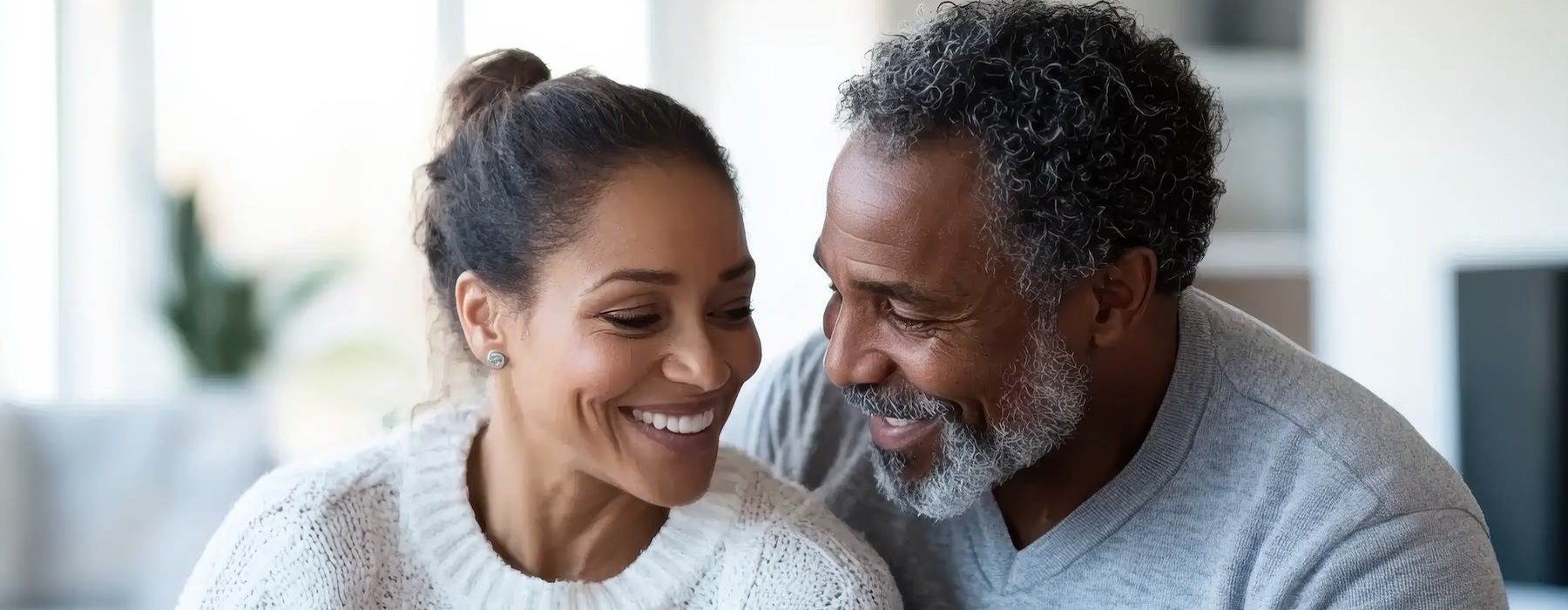 a man and a woman smiling and unpacking boxes