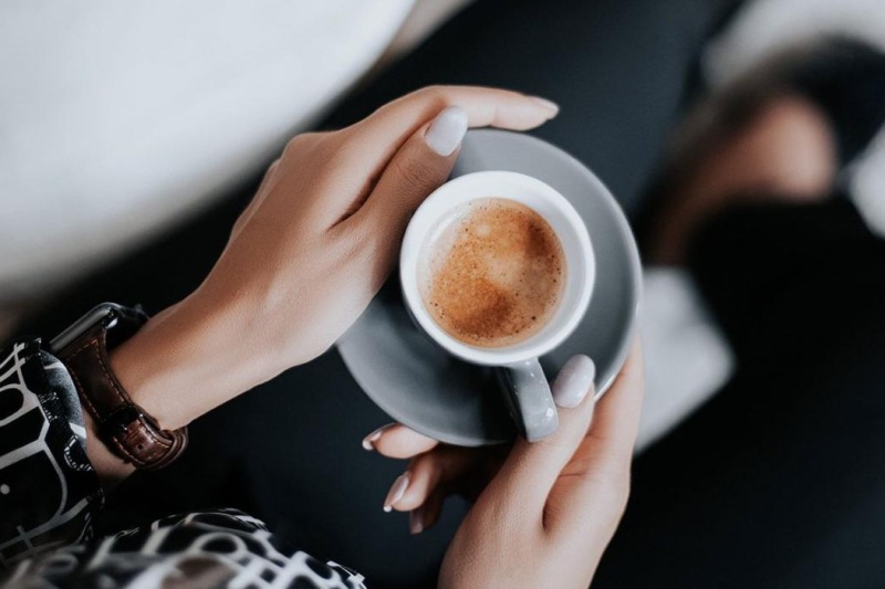 a person holding a cup of coffee