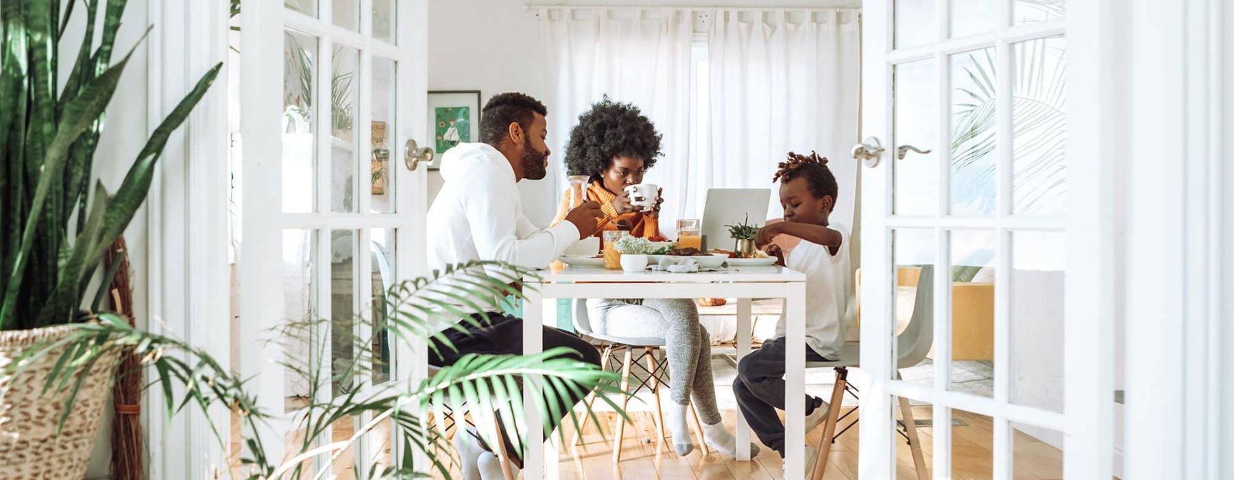 young family of three eat together at the breakfast table