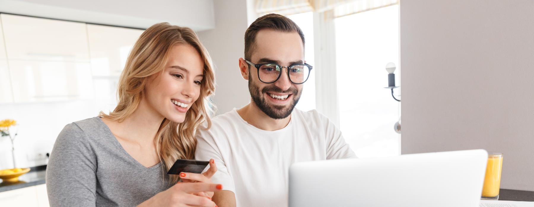 a man and a woman looking at a laptop