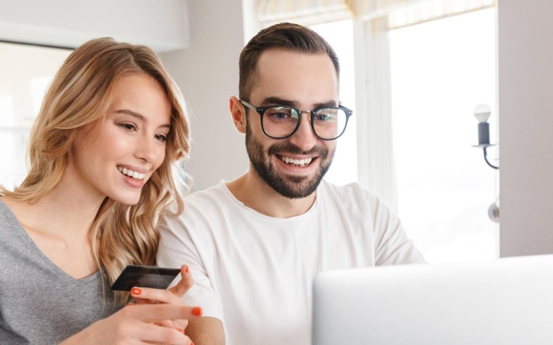 a man and a woman looking at a laptop